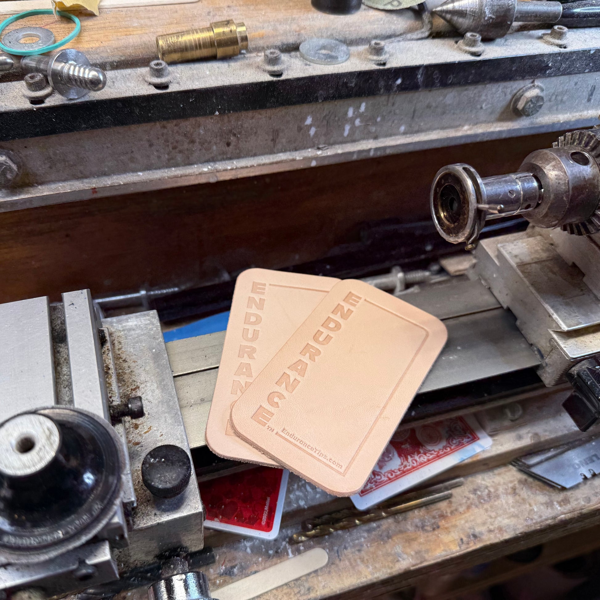 Two Endurance Leather Burnisher pads sitting on a billiards cue lathe.