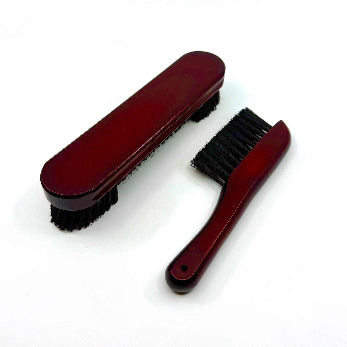 Image of a two-piece billiards brush set with mahogany wooden handles and soft nylon bristles for cleaning pool table rails and corners.