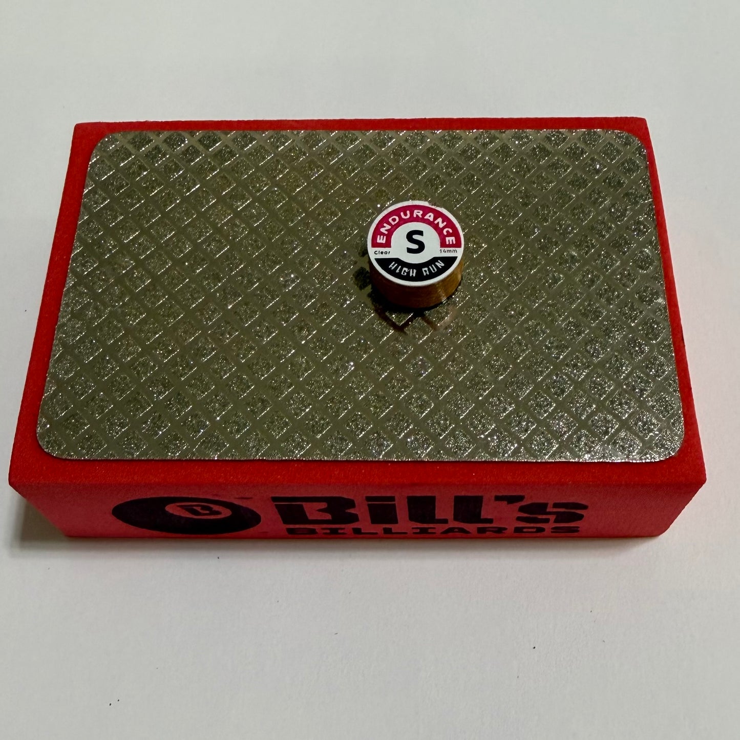 100 Grit Diamond Tip Prep Pad for Billiards Pool Cue Tips. Red pad on a white background, Endurance tip sitting on top of it. 