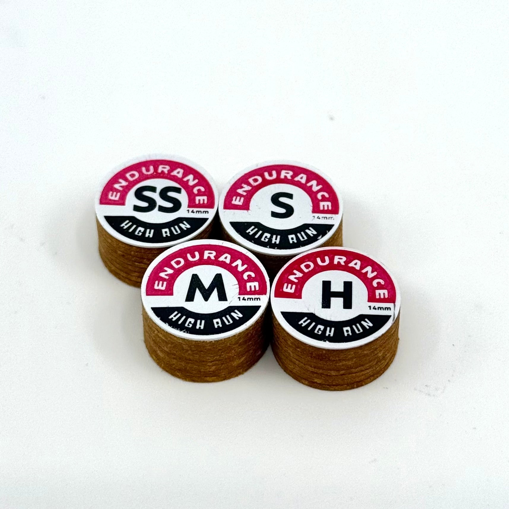 A set of four Endurance High Run brown pool cue tips arranged on a white surface, each tip has the brand name and 'HIGH RUN' text printed on it.