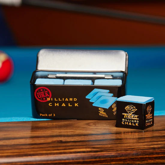 Tiger Billiards chalk on a pool table. Black can with a single square of chalk in front. 