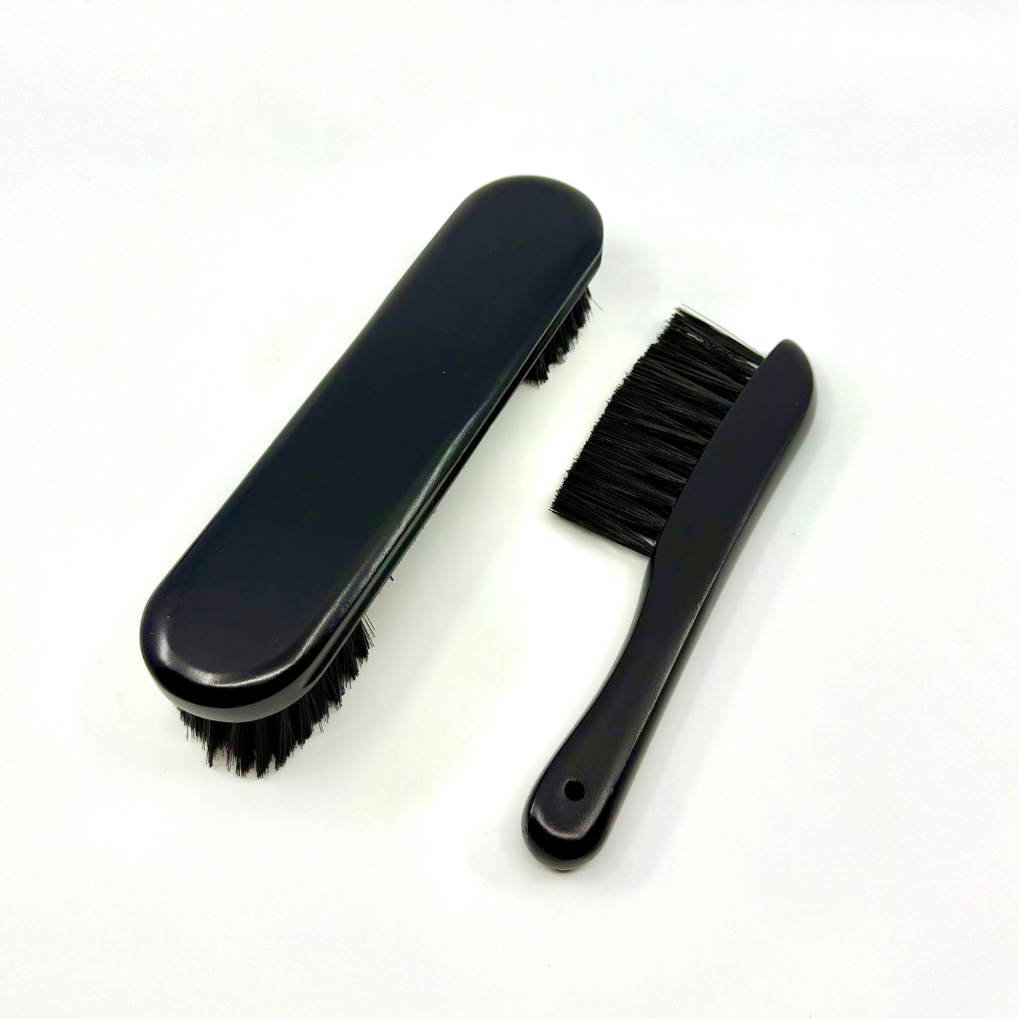 Image of a two-piece black billiards brush set with wooden handles and soft nylon bristles for cleaning pool table rails and corners