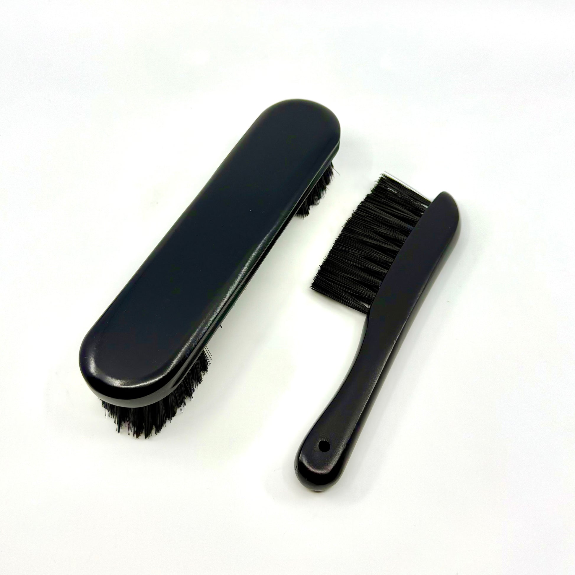 Image of a two-piece black billiards brush set with wooden handles and soft nylon bristles for cleaning pool table rails and corners